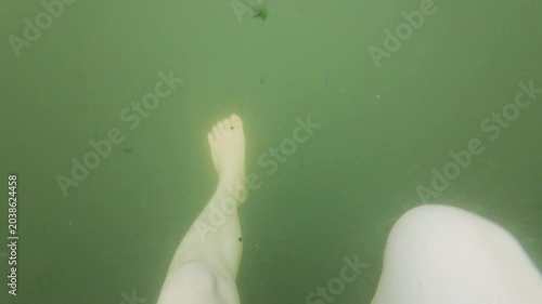 Barefoot and Leg Swimming Survival Submerged Underwater in Murky Green Water from Below