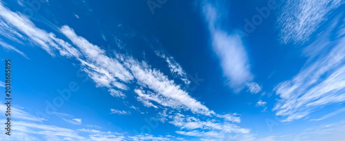 Fotografi Panoramic study of daylight sky: clear cerulean interrupted by ribbons of white cloud and feathery wisps diagonal patterns across scene