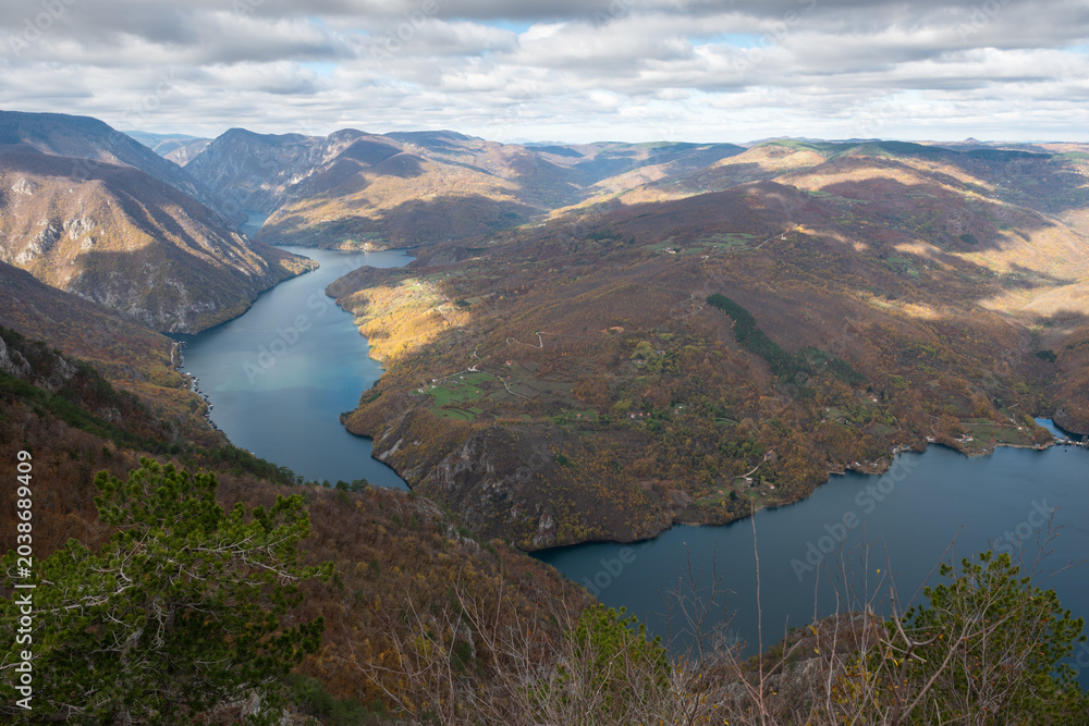 Fototapeta premium Artificial lake Perucac surrounded with mountains during cloudy day, view point Banjska stena on Tara mountain