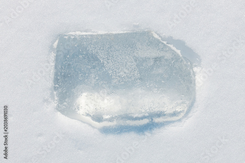 Φωτογραφία Ice block in the light blue tones on a white, fluffy snow background