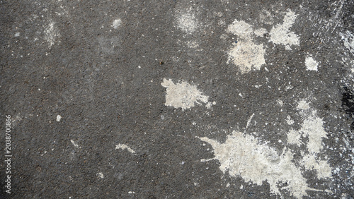 Photos Dark asphalt surface with scattered white chalky patches and stains