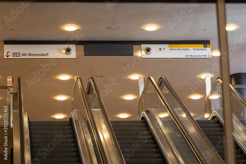 Foto Escalators rise beneath U6 wayfinding signs at Unter den Linden station in Berlin