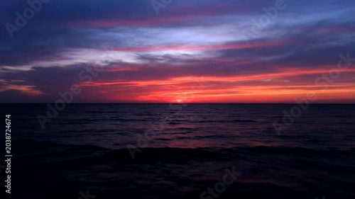 Sunset over calm ocean water horizon.