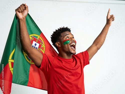Young man celebrating with Portuguese flag isolated on white