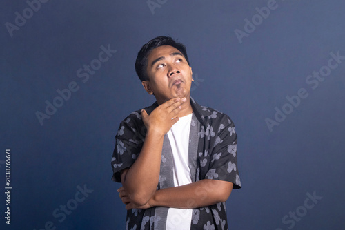 Tableau sur toile Indonesian man rolling eyes upward with a doubtful or sarcastic expression, hand
