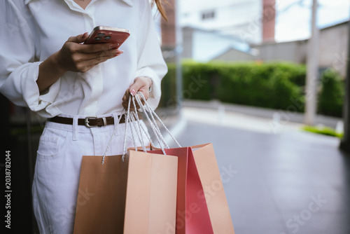 Close-up of a shopper carrying colorful shopping bags outdoors  symbolizing retail spending  consumer lifestyle  fashion purchases  and modern shopping experiences.