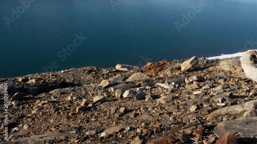 A rare Antarctic oasis with scattered lakes set in a vast frozen landscape under a bright, clear blue sky.
