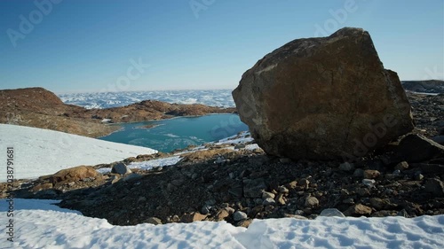 A striking Antarctic oasis emerges amid the frozen wilderness, with tranquil lakes reflecting a pristine blue sky.