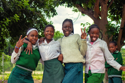 Authentic outdoor scene of smiling African schoolchildren in uniform enjoying time together. The image reflects joy, friendship, education, and the everyday reality of learning 