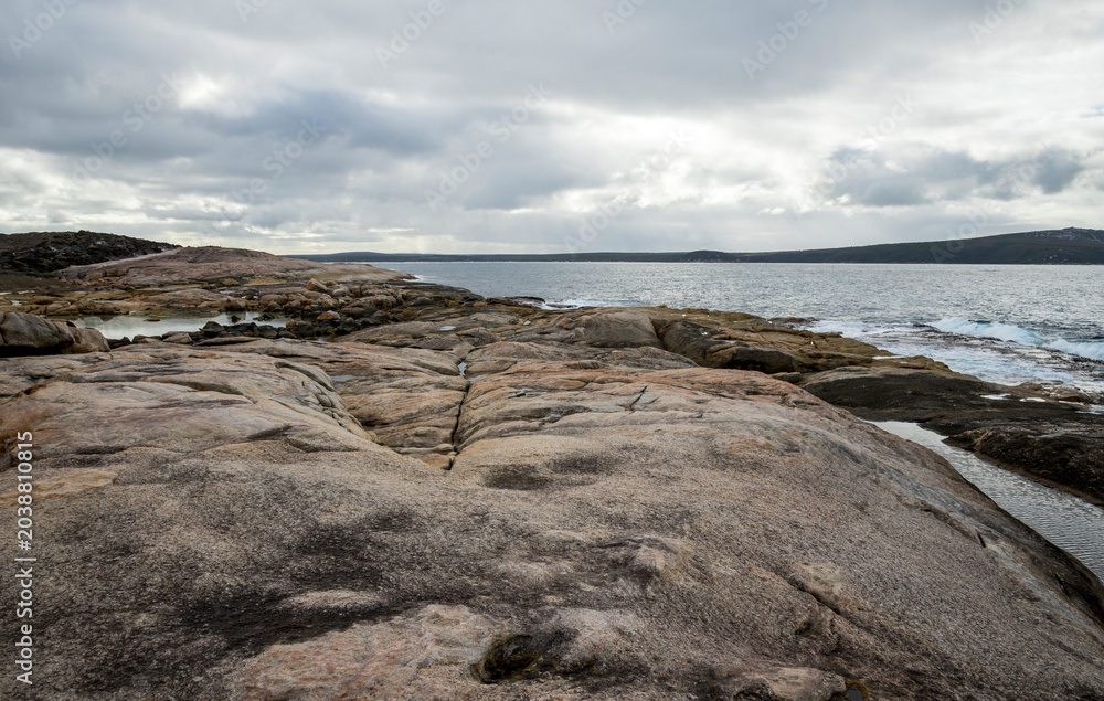 Fototapeta premium Granite rock formations overlooking calm bay waters in Two Peoples Bay Nature Reserve, Albany, Western Australia, 3 July 2024