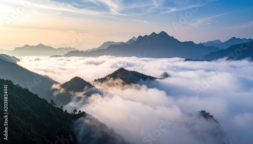 Majestic mountain peaks pierce through a sea of clouds at sunrise.