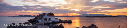 Panoramic view of Agios Isidoros chapel at sunrise with golden sun rays, Chios island, Greece.