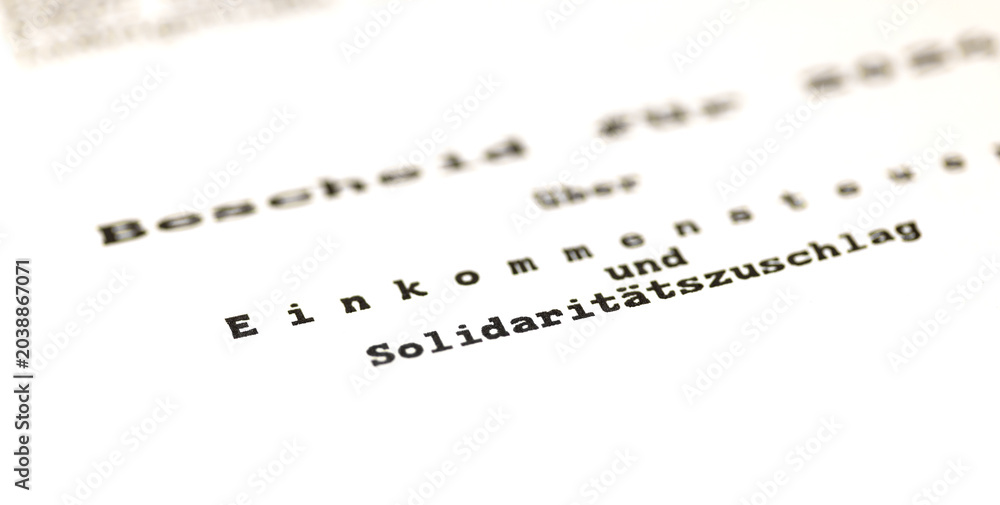 Fototapeta premium Close-up of a German tax certificate (Einkommensteuer), a document used to determine income tax refunds or additional payments. Tax office, application, allowance, tax return for individuals.