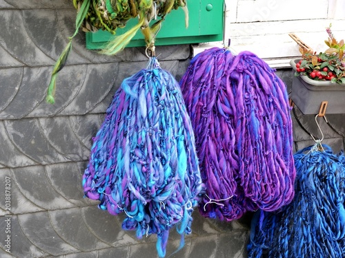Tableau sur toile A close-up texture shot captures thick, textured bundles of hand-spun wool yarn
hanging from metal hooks