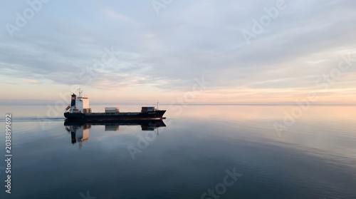 Cargo Ship Sailing on Calm Sea Minimalist Horizon Scene