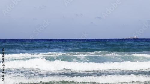 Sea water is wrapped in waves forming white foam. Beautiful background of colorful sea. High quality 4k footage