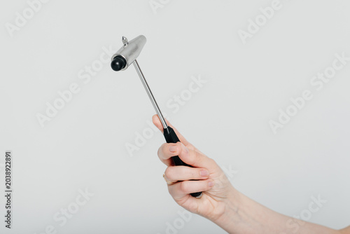 Fotografia neurologist holds neurological reflex hammer for testing human reflexes in hand,