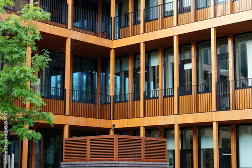 Modern residential building with natural wooden facade and windows