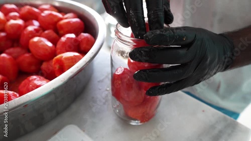 Peeled Tomatoes Being Placed into Glass Jar in Tomato Paste Production