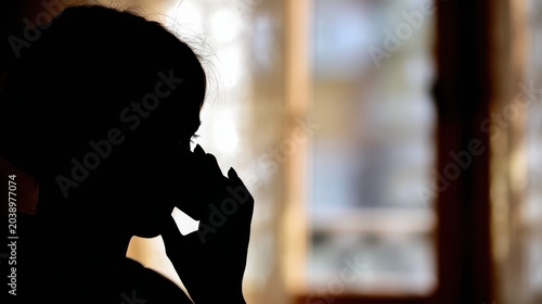 Person communicating using phone in backlighting silhouette