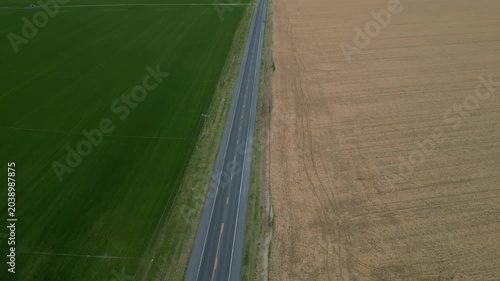 Drone footage rising upward over the Delmarva Peninsula, revealing a dark rural road running through the landscape