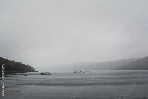 Abandoned small wooden boats floating on calm water, Isle of Skye, Scotland