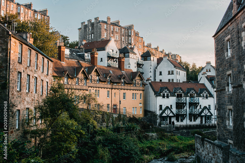 Obraz premium Picturesque historic stone houses of Dean Village by the Water of Leith, Edinburgh, Scotland