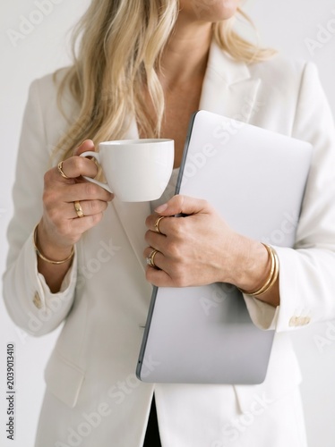Elegant Businesswoman Working with Laptop and Coffee in Bright Modern Office