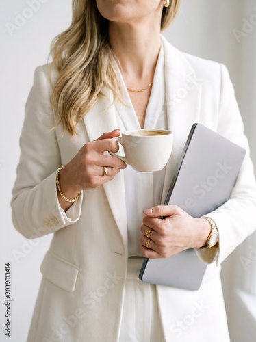 Elegant Businesswoman Working with Laptop and Coffee in Bright Modern Office