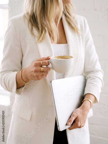 Elegant Businesswoman Working with Laptop and Coffee in Bright Modern Office
