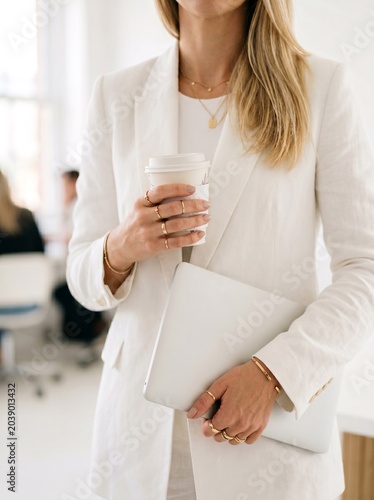Elegant Businesswoman Working with Laptop and Coffee in Bright Modern Office