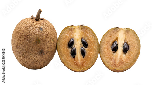 Three sapodilla fruits, one whole and two halves, revealing the dark seeds within their sweet flesh. These tropical fruits, also known as chico or manilkara zapota, offer a unique taste experience