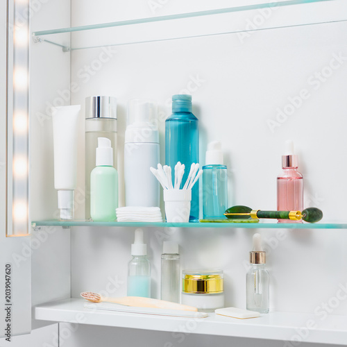 Foto Skincare products are displayed on a shelf in a bathroom cabinet