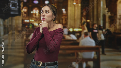 Φωτογραφία Woman with clasped hands at chest and closed eyes in ornate cathedral building; prayerful contemplation