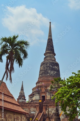 Photos Ancient brick chedi rising above tropical trees at Wat Yai Chai Mongkhon temple complex in Ayutthaya, Thailand