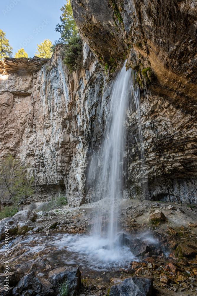 Obraz premium Long exposure image of Spouting Rock waterfall in White River National Forest, Colorado on clear sunny spring morning.