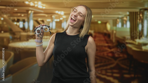 Foto Woman holds trial frame and beckons with hand while wearing glasses in studio; confidence vision care
