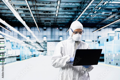Tableau sur toile Technician man inspecting semiconductor production infrastructure with laptop, optimizing photolithography process, Worker trialing advanced materials for silicon wafers using notebook