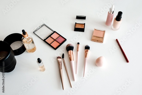 Fotografie Sleek Collection Of Various Makeup Products Including Palettes, Bottles, And Brushes Arranged Neatly On White Surface, Perfect For Beauty Enthusiasts, Makeup Artists, And Cosmetic Brands