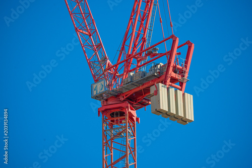 Fotografie Tower crane structure against a clear blue sky on a construction site