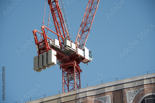 Canvas-taulu Tower crane with counterweights against a clear blue sky at a construction site