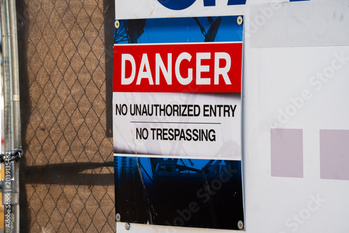 Obraz na plátne Danger sign warns of no unauthorized entry and no trespassing on property