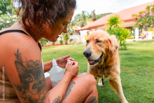 Foto Woman providing pet care for a golden retriever dog