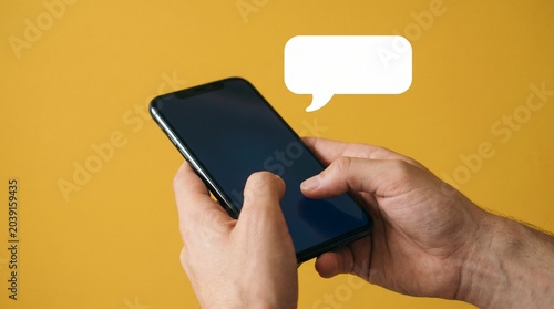 Person Typing on Phone Yellow Background with Chat Bubble