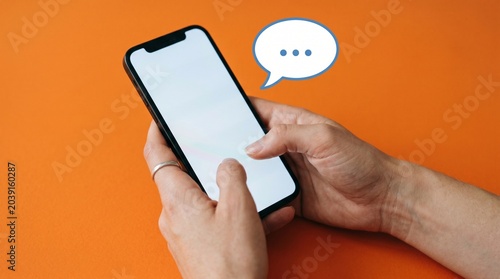 Hands Texting on Mobile Phone Yellow Neutral Background