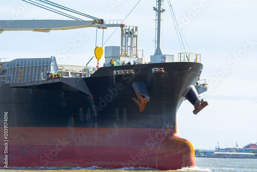 Bild auf Leinwand Cargo ship bow anchor ocean harbor steel crane sunlight, massive freighter near