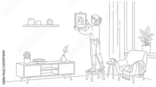 Bild auf Leinwand A person carefully hangs a framed picture on the wall, decorating their cozy liv