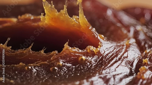 Closeup of a delicious dried fig with syrupy texture and glistening surface.