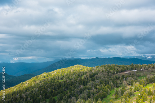 Scenic aerial top view from above to hilly woody vastness and dark silhouette...