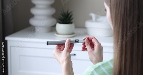 Diabetes. Woman with autoinjector at home, closeup
